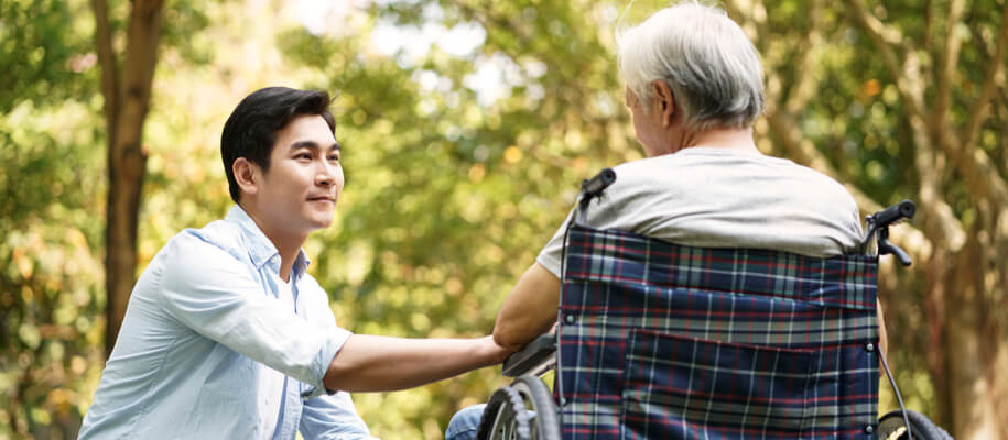 Respite care worker calms senior patient in a wheelchair at the respite care facility.