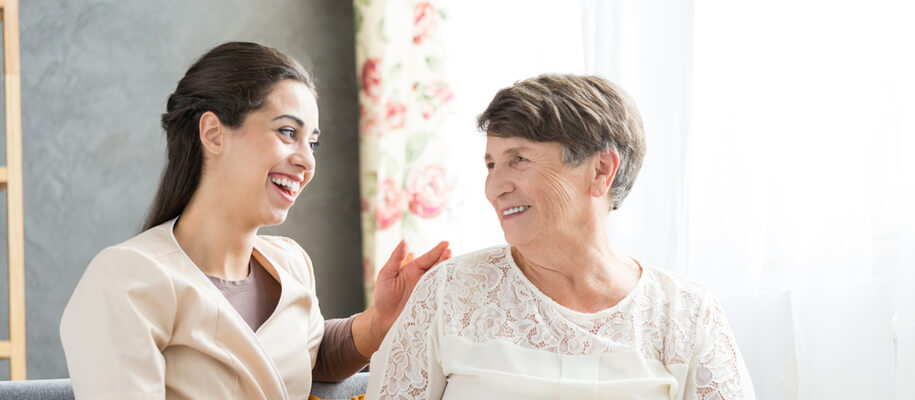 A woman staff and woman resident at a transitional care center.